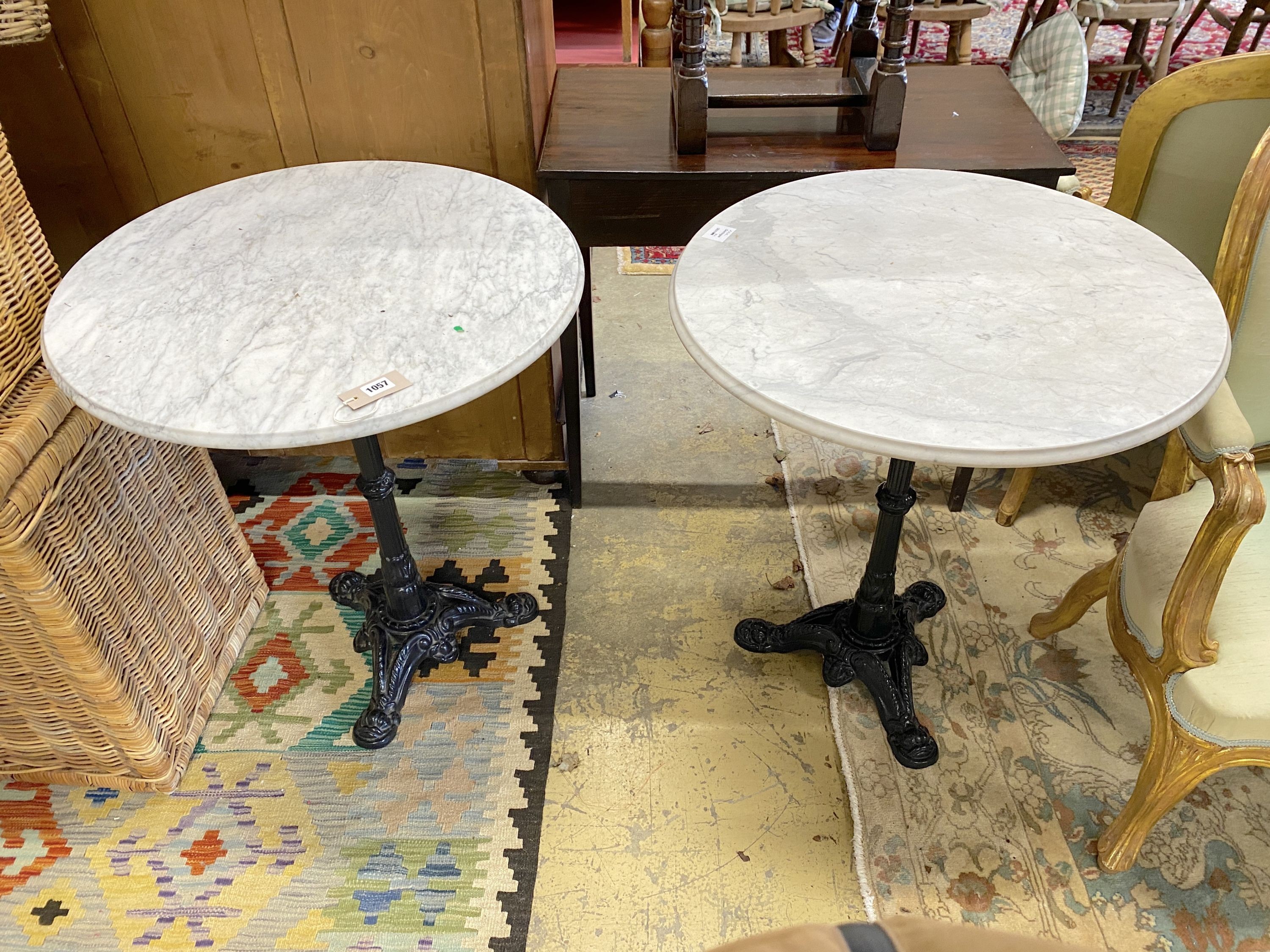 A pair of Victorian style cast iron circular marble topped pub tables, diameter 64cm, height 72cm